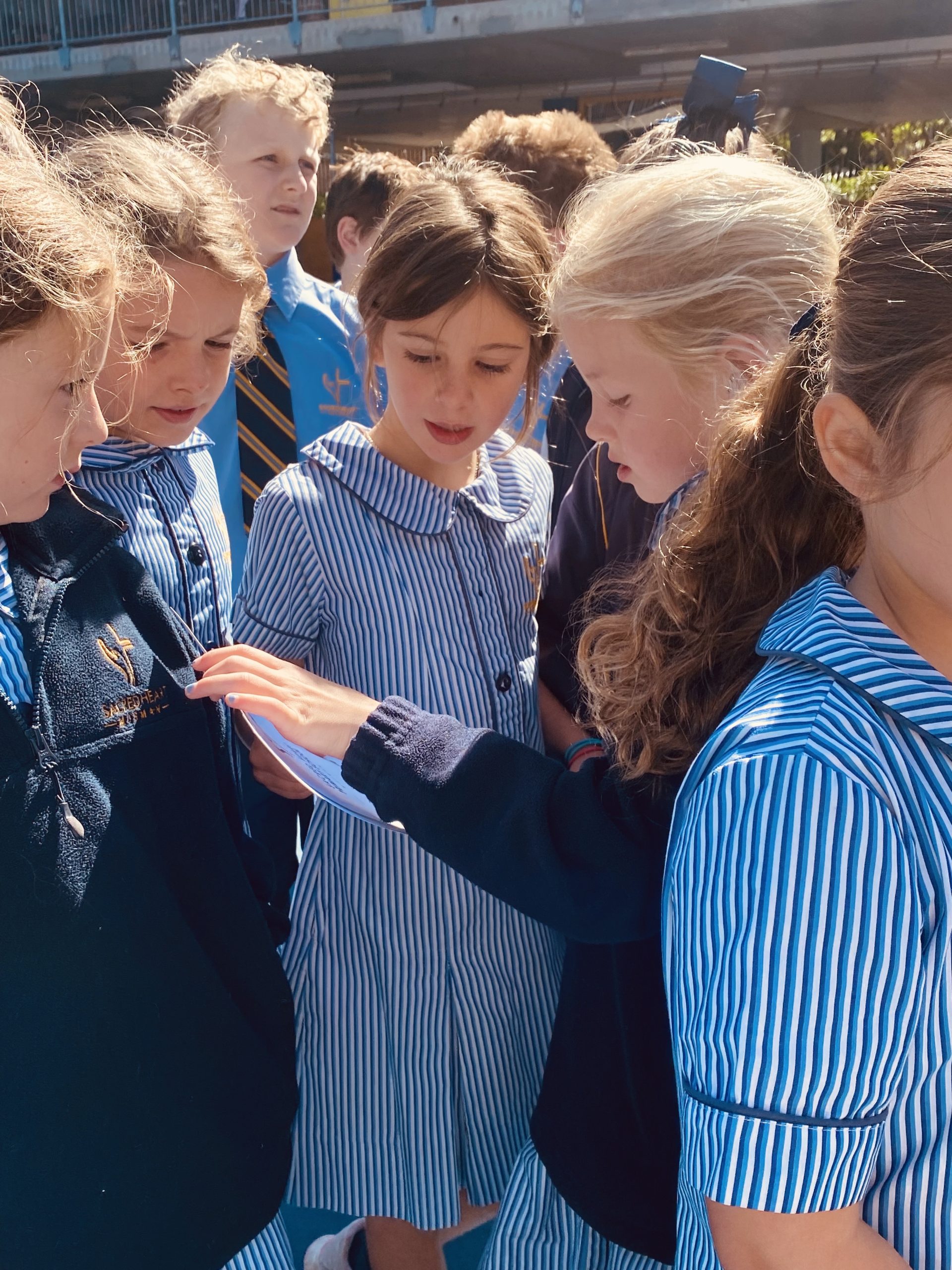 Evie showing her award to her friends at school